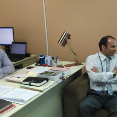 Dos hombres sentados en escritorio conversando 