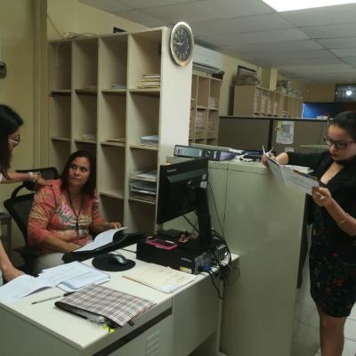 Tres mujeres en oficina revisando información en computadora