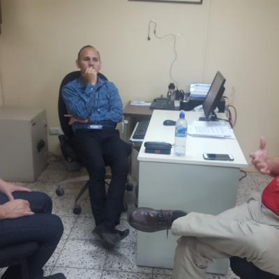 Tres hombres conversando en oficina
