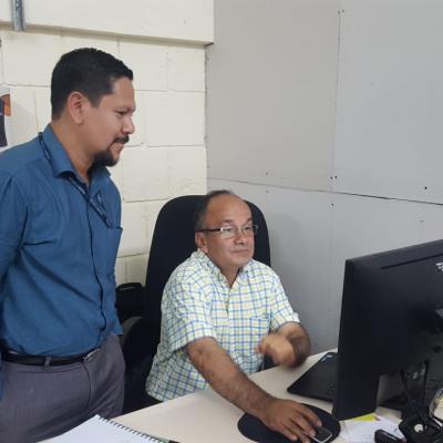 Dos hombres conversando en escritorio