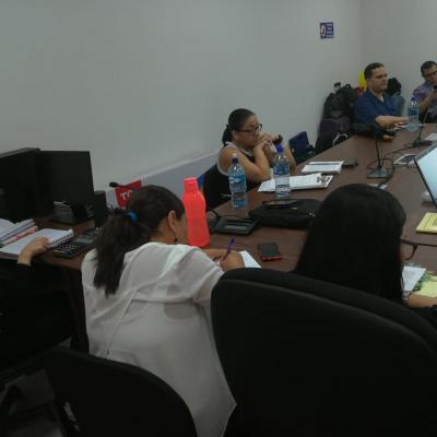 Grupo de personas sentadas en mesa de reuniones