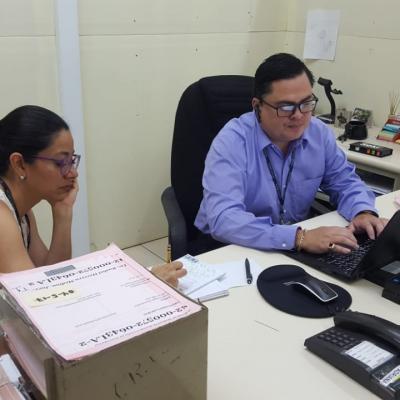 Hombre y mujer sentados en escritorio conversando