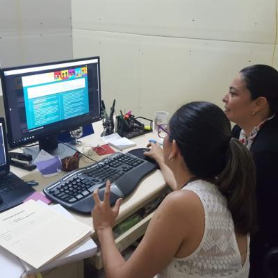 Dos mujeres sentadas en escritorio viendo sitio web