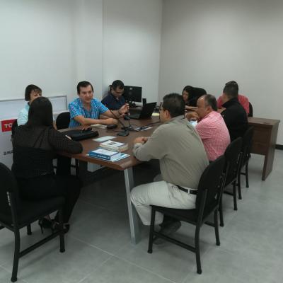 Grupo de personas sentadas en sala de reuniones