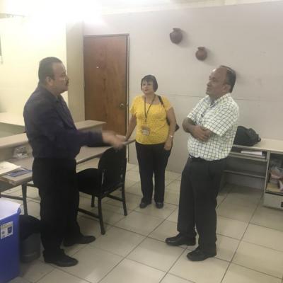 Dos hombres y una mujer de pie conversando