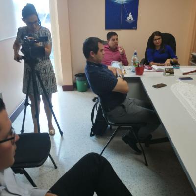 Grupo de personas sentadas en sala de reuniones