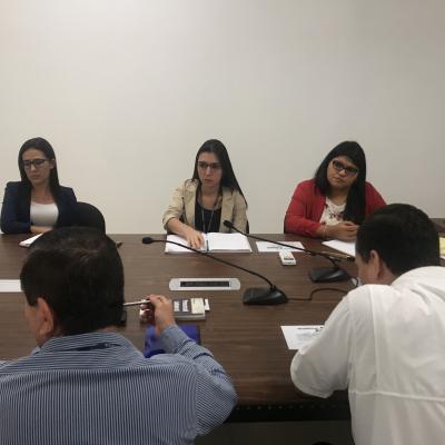 Grupo de personas sentadas en sala de reuniones