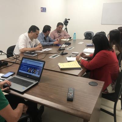 Grupo de personas sentadas en sala de reuniones