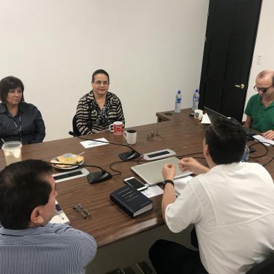 Grupo de personas sentadas en sala de reuniones
