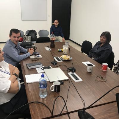 Grupo de personas sentadas en sala de reuniones