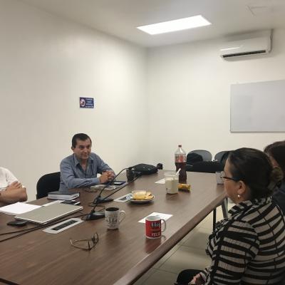 Grupo de personas sentadas en sala de reuniones