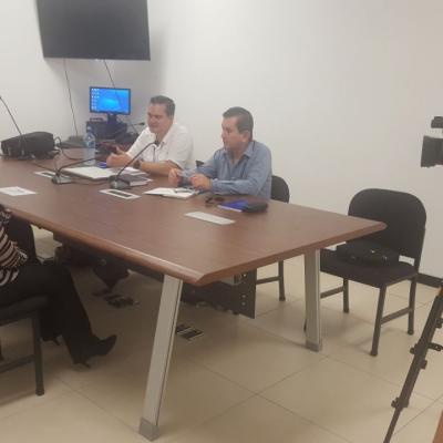 Dos hombres siendo entrevistados en sala de reuniones