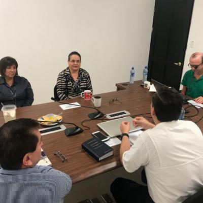Grupo de personas sentadas en sala de reuniones