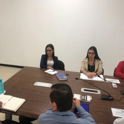Grupo de personas sentadas en sala de reuniones
