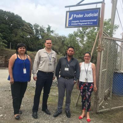 Cuatro personas posando para la cámara frente al juzgado del Poder Judicial