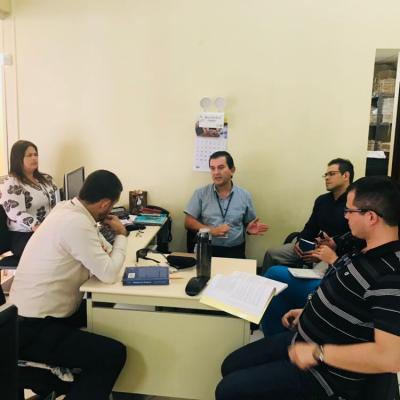 Grupo de personas reunidas en escritorio conversando