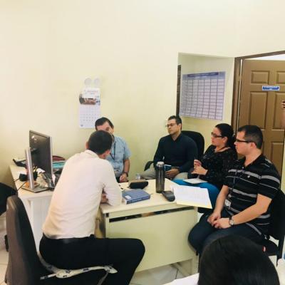 Grupo de personas reunidas en escritorio conversando