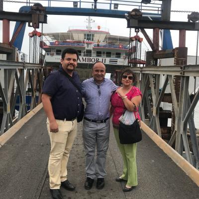 Tres personas de pie sonriendo en el muelle de Cóbano
