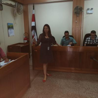 Mujer de pie exponiendo en un juzgado