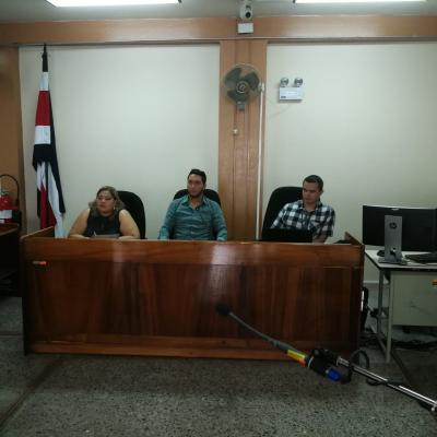 Tres hombres sentados en un juzgado