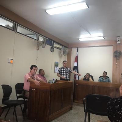 Hombre de pie debatiendo con otras personas 
