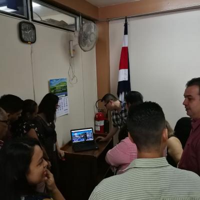 Personas de pie discutiendo y observando una computadora