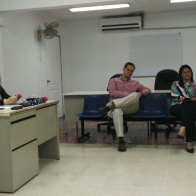 Hombre sentado en su escritorio atendiendo a unas personas
