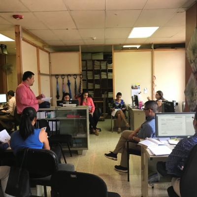Hombre de pie exponiendo frente a un grupo de personas