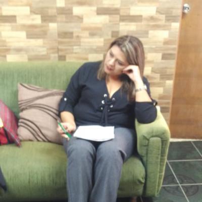 Mujer sentada en sillón revisando folleto