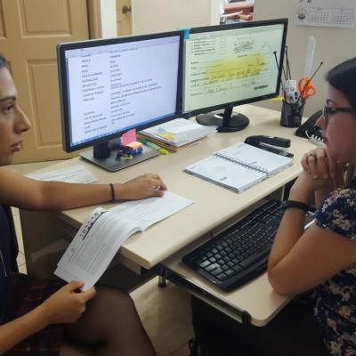 Dos mujeres sentadas discutiendo en su escritorio