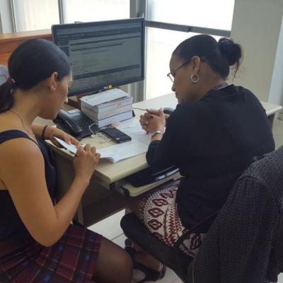 Dos mujeres sentadas en el escritorio leyendo unos documentos