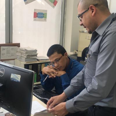 Hombre mostrándole un documento a su compañero de trabajo