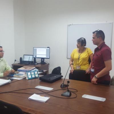 Hombre atendiendo a dos personas en su oficina