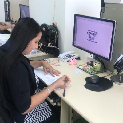Mujer escribiendo en unos documentos en su oficina