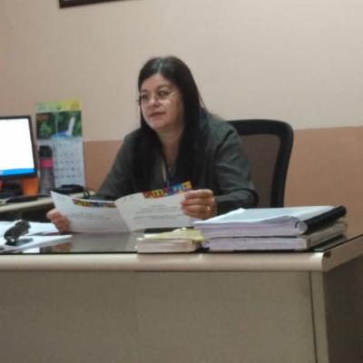Mujer sentada en su escritorio revisando folleto