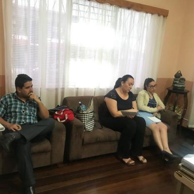 Dos mujeres y un hombre conversando en sala