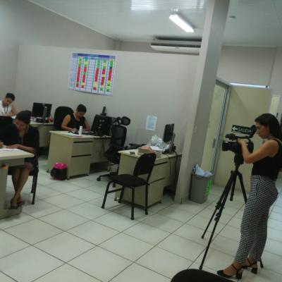 Mujer filmando a grupo de personas en sus escritorios