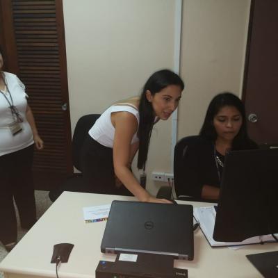 Mujer utilizando la computadora junto con sus compañeras de trabajo