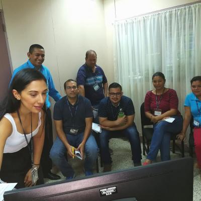 Trabajadores reunidos observando un monitor