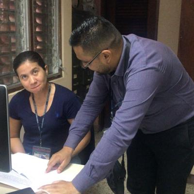Hombre analizando un documento junto a su compañera de trabajo