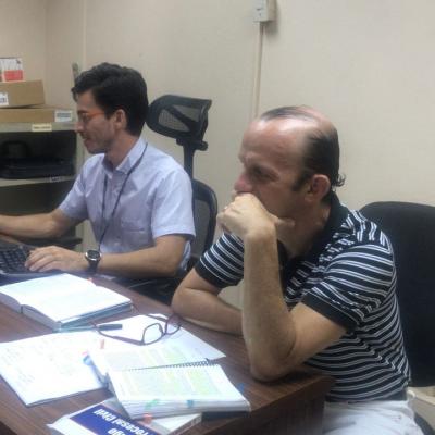 Dos hombres sentados en su escritorio y utilizando una computadora