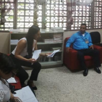 Mujer atendiendo a tres personas en su oficina