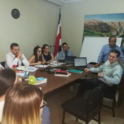 Grupo de personas sentadas en sala de reuniones