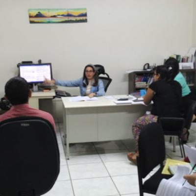 Mujer presentando en un monitor frente a su equipo de trabajo