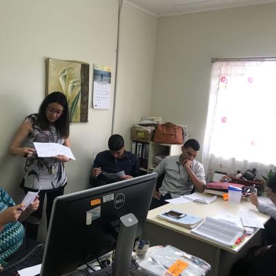 Mujer de pie explicándole a sus compañeros de trabajo