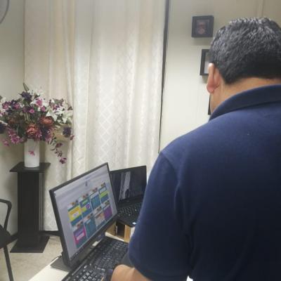 Hombre de pie observado una computadora