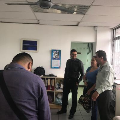 Personas de pie conversando dentro de una oficina