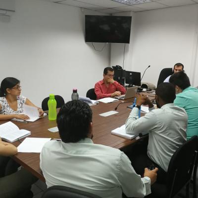 Personas reunidas alrededor de una mesa en una sala de sesiones 