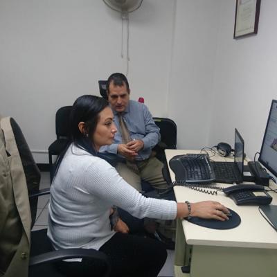 Mujer utilizando su computadora y hombre al lado