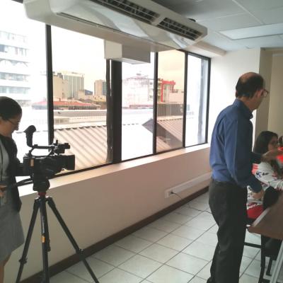 Mujer grabando con una cámara profesional a un grupo de personas